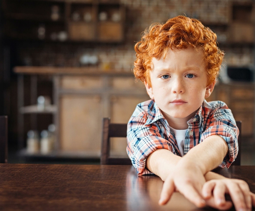 klein jongetje rood haar armen voor zich