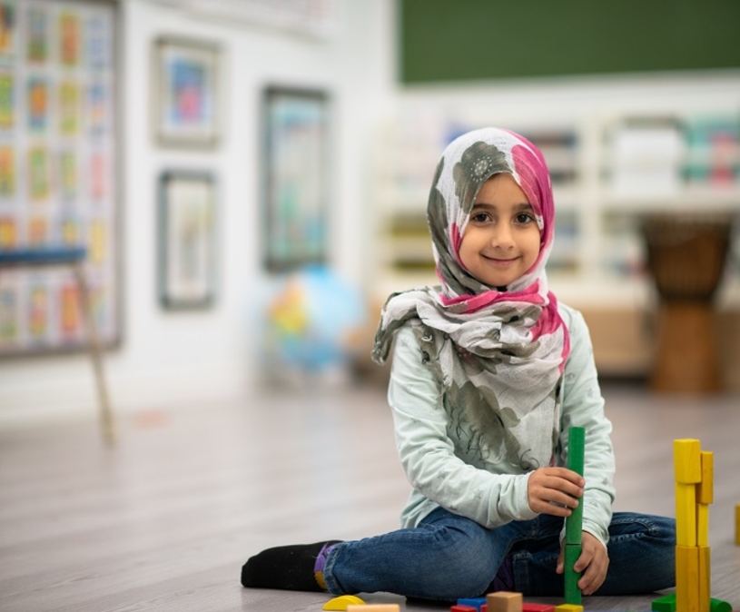 spelende peuter meisje met hoofddoek