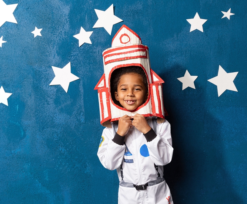 kind verkleed als astronaut tegen een achtergrond met sterren