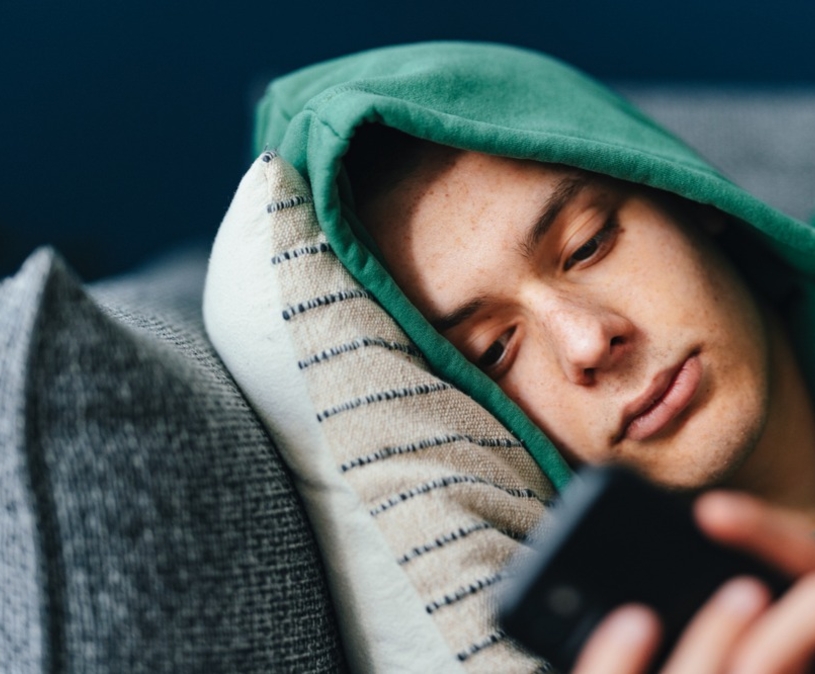 Sombere jongen met telefoon
