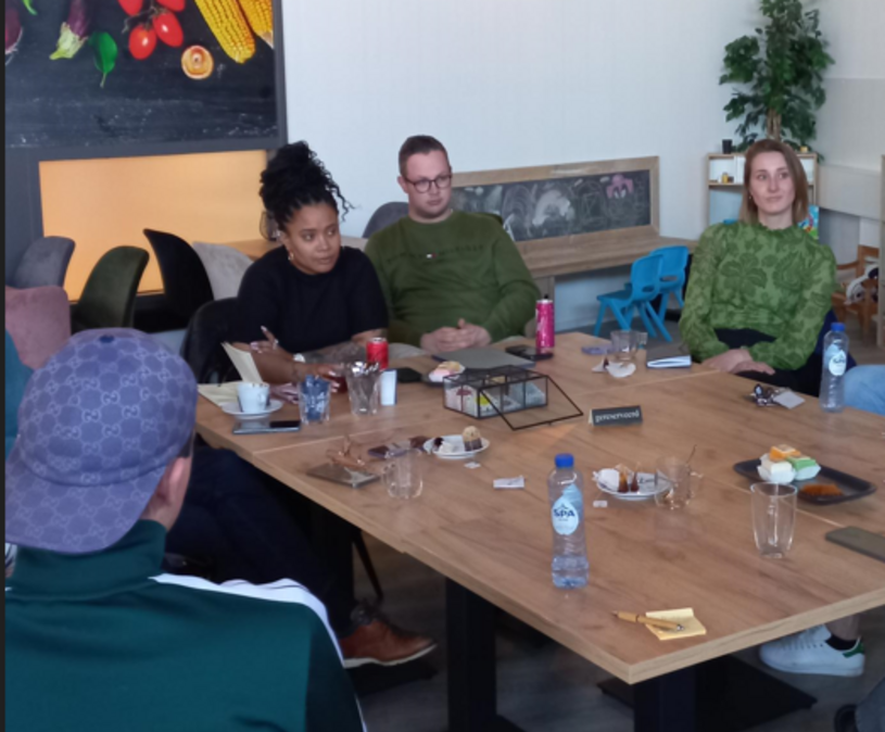Faith Bruyning aan tafel in gesprek met een jongere en andere betrokkenen