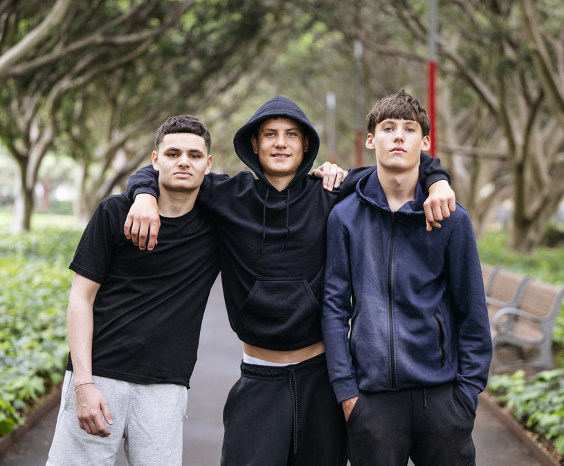 3 tiener jongens in sportkleding kijken in de camera