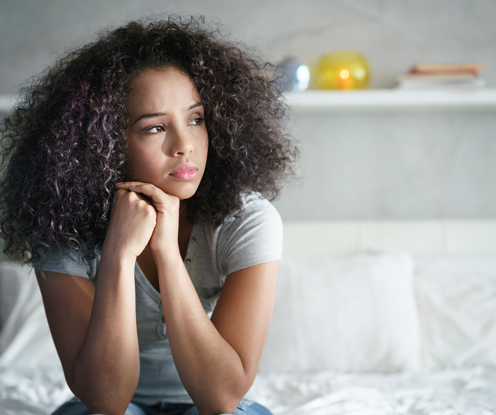 meisje zittend op bed peinzend