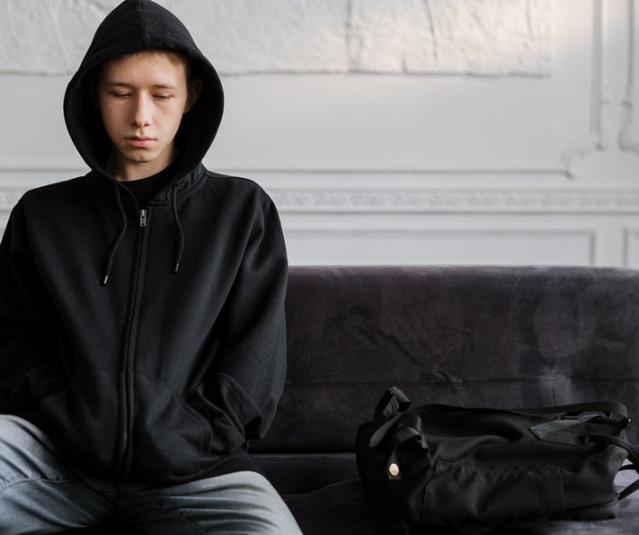 ervaringsverhaal jongen op bank met capuchon
