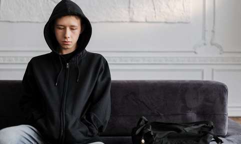 ervaringsverhaal jongen op bank met capuchon