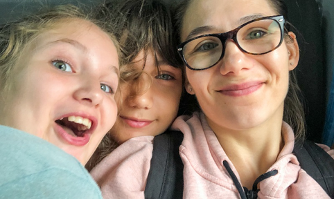 moeder en twee kinderen kijken in de camera