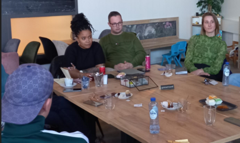 Faith Bruyning aan tafel in gesprek met een jongere en andere betrokkenen