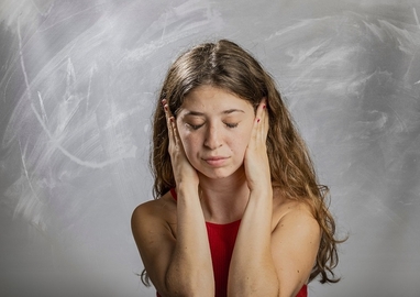 meisje houdt haar handen over haar oren en haar ogen dicht