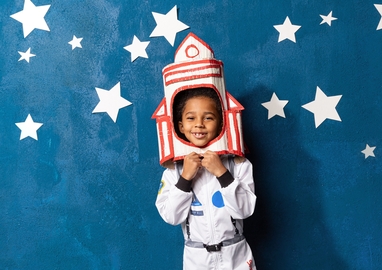 kind verkleed als astronaut tegen een achtergrond met sterren