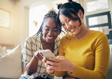 twee vrouwen kijkend naar de telefoon