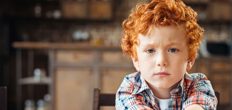 klein jongetje rood haar armen voor zich