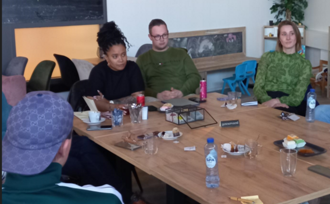 Faith Bruyning aan tafel in gesprek met een jongere en andere betrokkenen